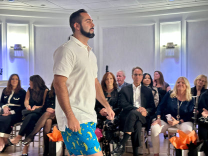 Man walking on a runway with an audience watching.