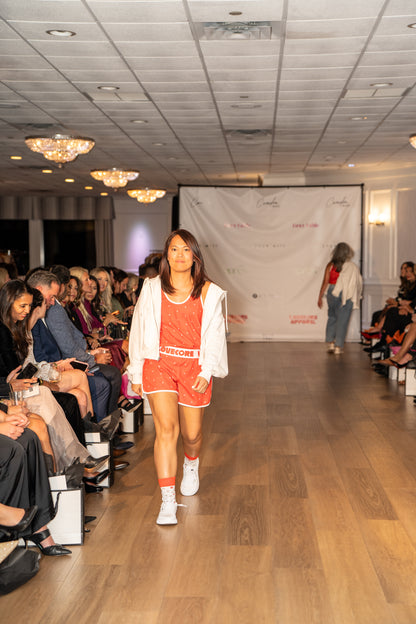 Model wearing Love Buzz Set walking on a runway in a fashion show setting.